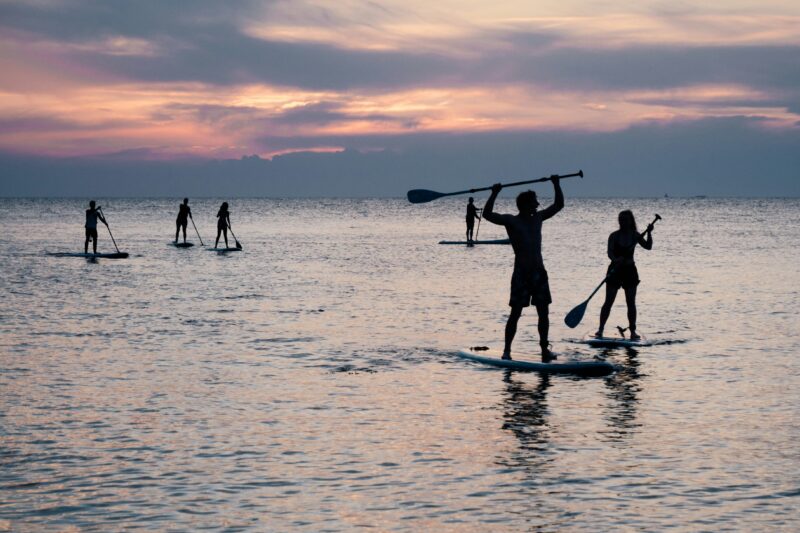 Silhouette of person paddleboarding at golden sunset on the Red Sea
